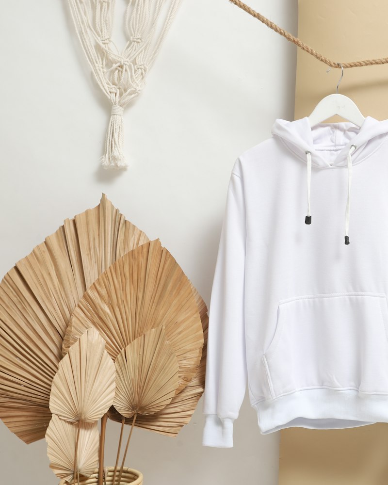 A white hoodie hanging beside light jeans