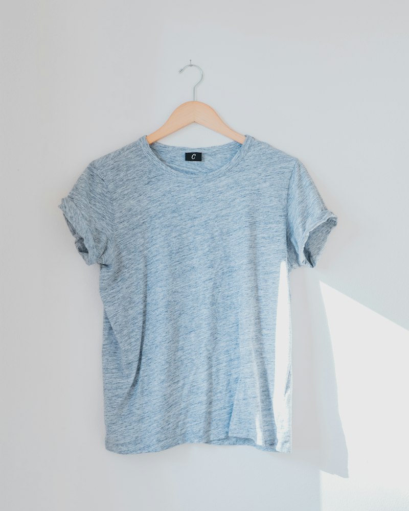 A light blue t-shirt hanging on a wall