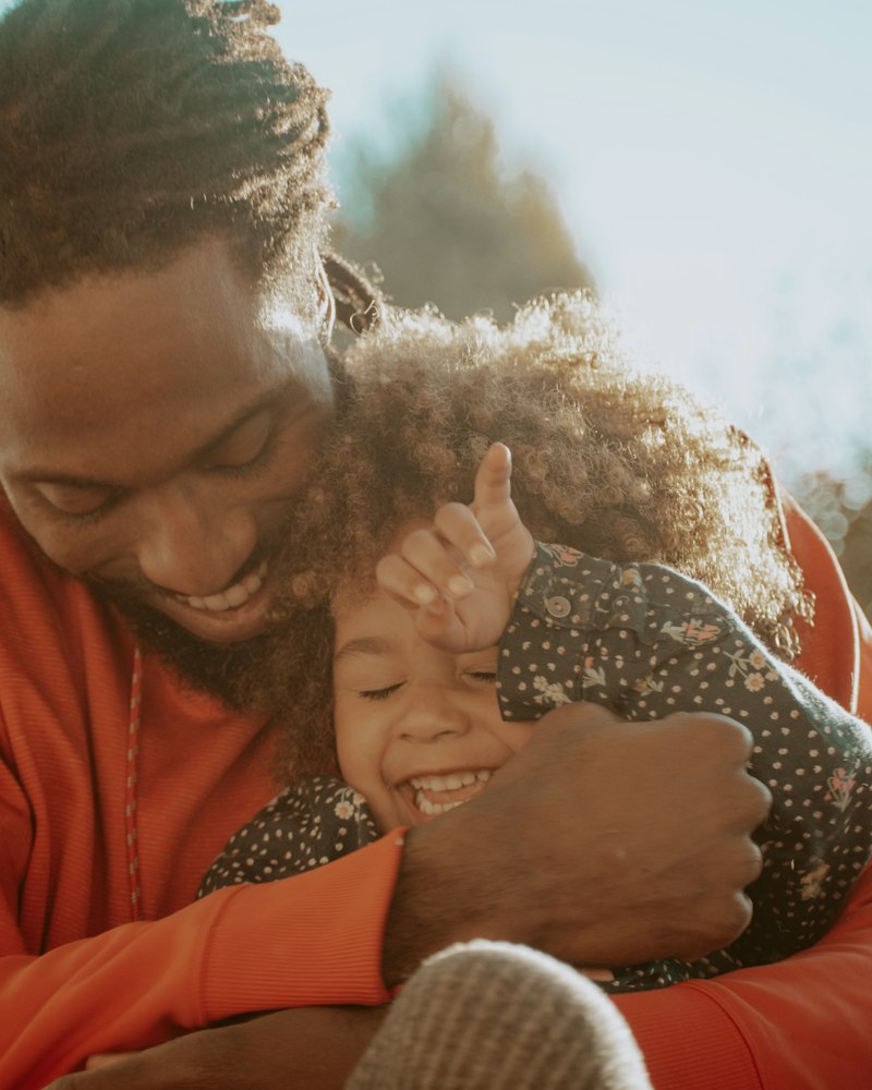 A father hugging his laughing young daughter
